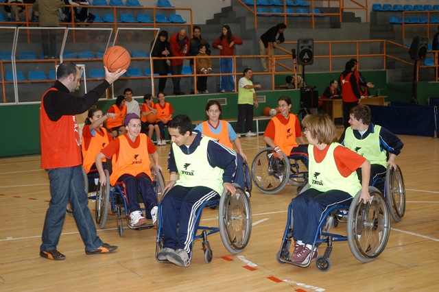 Victor un voluntario de oro con deportistas en baloncesto en silla de ruedas
